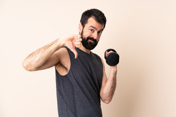 Caucasian sport man with beard making weightlifting over isolated background showing thumb down...