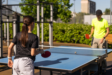 Family playing table tennis outside house