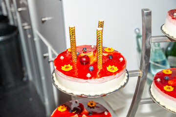 A red cake with candles on top of it