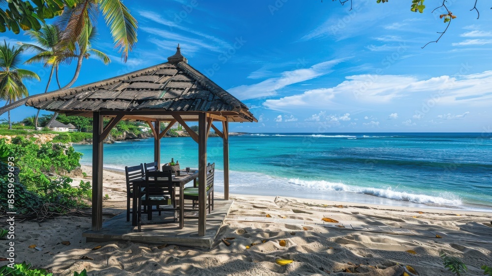 Poster A beach hut with a table and chairs is set up on the beach. The hut is under a large umbrella and is surrounded by trees. The beach is calm and peaceful, with the ocean in the background