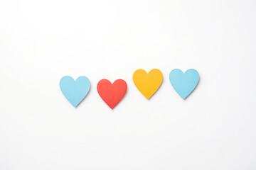 Four paper hearts in a row on a white background