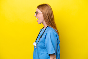 Young redhead nurse woman isolated on yellow background laughing in lateral position