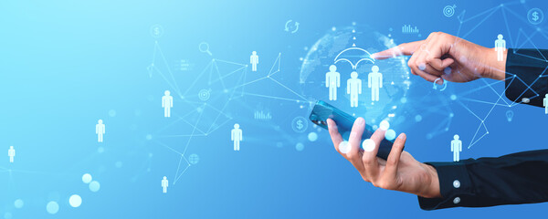 Hands using a smartphone with a digital network of people icons in the foreground on a light blue background, illustrating the concept of networked business connections