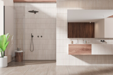 Tile home bathroom interior with sink and glass shower, accessories on drawer