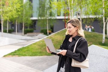 Young business woman working at laptop in the city