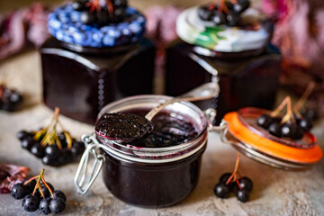 Chokeberry jam in a glass jar. Close-up