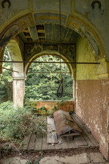 Abandoned Building with Hanging Rope and Overgrown Foliage