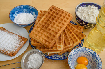 Idealne ciasto na domowe gofry, składniki i gotowe gofry leżą na stole