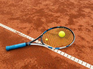 Close up view of tennis racket and ball on the clay tennis court