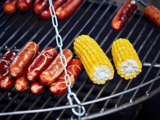 Sausages and corn are grilled on the barbecue grill