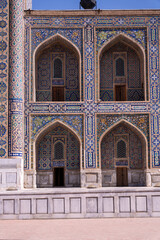 Obraz premium The building is decorated with blue and white tiles. The arches are ornate and the doors are wooden