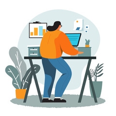 A woman standing next to her table and working on her computer