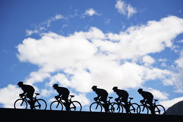 Lanslebourg-Mont-Cenis , France - June 20 2024: A group of cyclists tackle the steep Alpine climb in the back light.
