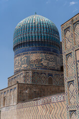 A blue dome on top of a building with Arabic writing. The building is old and has a lot of detail