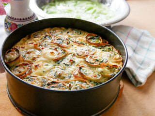 baked rolled filled pancakes with melted cheese on the top in the tin