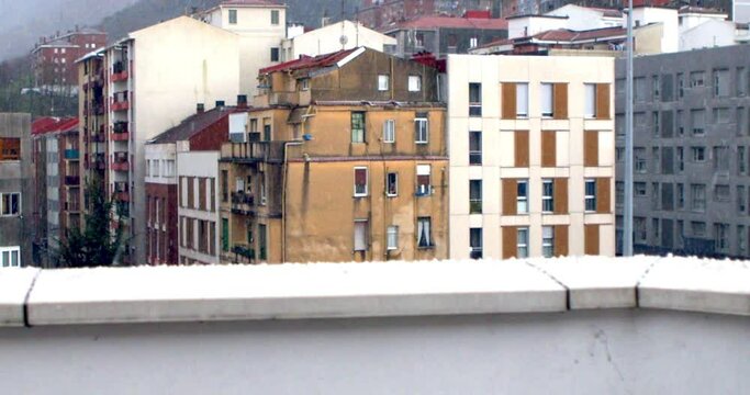 Granizo sobre muro, cambio de foco a edificio ciudad