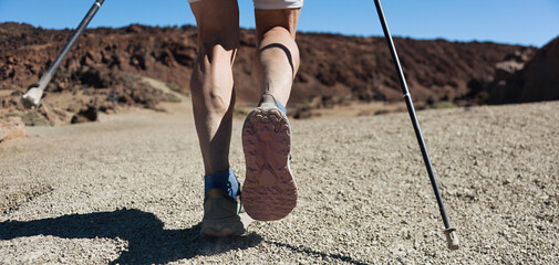 Man hiking in mountains adventure and exercising. Nordic walking in sunny summer nature outdoors....
