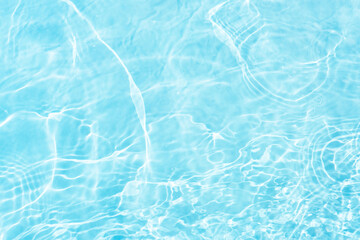 Blue water with ripples on the surface. Defocus blurred transparent blue colored clear calm water surface texture with splashes and bubbles. Water waves with shining pattern texture background.