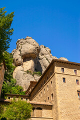 Fototapeta premium Spectacular rock formations stand out above the Montserrat Abbey buildings in Catalonia