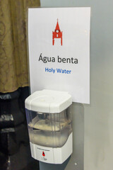 Água benta (tr: Holy water) dispenser at the entrance of a Roman Catholic church in Portugal.