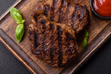 Fresh juicy delicious beef steak on a dark background