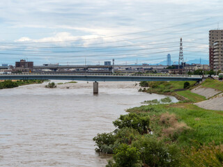 Obraz premium 大雨で河川敷が水没した大和川と街の風景