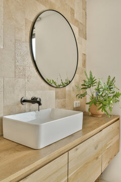 Modern bathroom sink with natural stone wall at Jan Vrijmanstraat 98