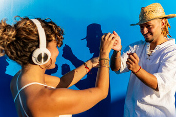 Street dancers sharing a cheerful moment against a blue wall
