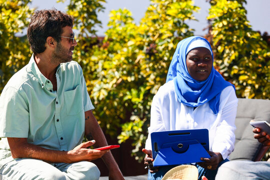 Diverse business meeting outside with Caucasian and Muslim woman