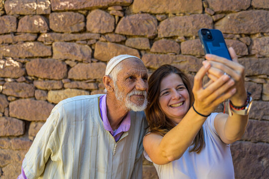 Elderly Moroccan man and young woman taking a selfie together - Powered by Adobe