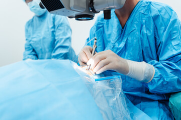 Skilled surgeon and his medical team performs precise eye surgery on an elderly patient, restoring...