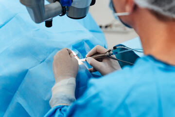 Skilled surgeon and his medical team performs precise eye surgery on an elderly patient, restoring...