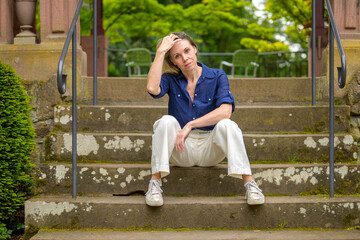 Reflective Mother Sitting on Steps in the Park
