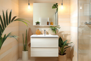 A Scandinavian-style bathroom with light wood finishes, a simple white vanity, and potted plants adding a touch of greenery. The walls are tiled in a soft pastel shade.