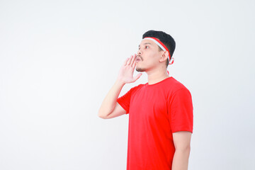 excited young asian man shouting and screaming loud with a hand on his mouth. Indonesia's independence day concept.