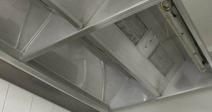 Close-up Interior of a restaurant kitchen, sleek metallic extractor hood. Functional design elements of the kitchen. Cleanliness and professional culinary equipment. Restaurant infrastructure concept.