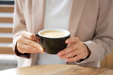 カフェでカフェラテを飲むビジネスウーマン　顔無し