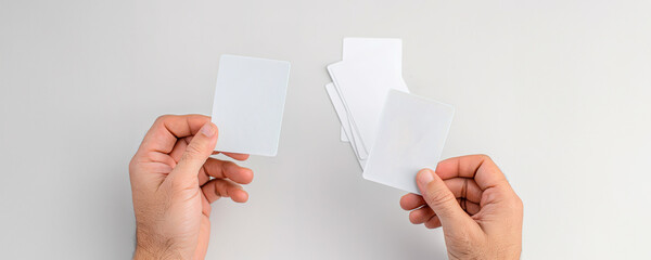Two hands holding blank cards on a white background with copy space.