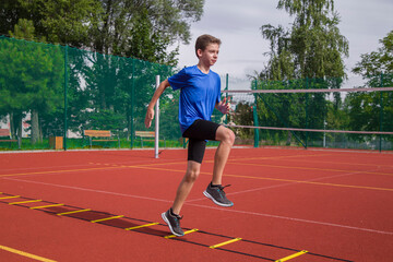 An athlete does special running exercises on a ladder.
