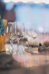 Luxury table settings for fine dining with and glassware, pouring wine to glass. Beautiful blurred background. Preparation for holiday wedding. Fancy luxury restaurant.