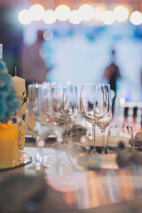 Luxury table settings for fine dining with and glassware, pouring wine to glass. Beautiful blurred background. Preparation for holiday wedding. Fancy luxury restaurant.