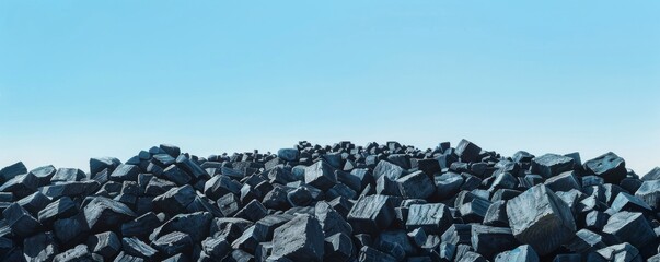 Pile of charcoal blocks under clear blue sky, minimalistic nature concept