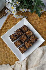 Kuih kole kacang, a steamed Malaysian cake, made with fried green bean flour, coconut milk, and palm sugar.  The decoration of the cake is from coconut oil grease or residue. Selective focus.