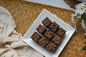 Kuih kole kacang, a steamed Malaysian cake, made with fried green bean flour, coconut milk, and palm sugar.  The decoration of the cake is from coconut oil grease or residue. Selective focus.