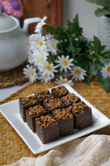 Kuih kole kacang, a steamed Malaysian cake, made with fried green bean flour, coconut milk, and palm sugar.  The decoration of the cake is from coconut oil grease or residue. Selective focus.