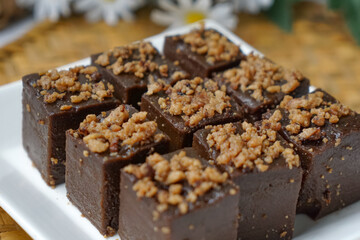 Kuih kole kacang, a steamed Malaysian cake, made with fried green bean flour, coconut milk, and palm sugar.  The decoration of the cake is from coconut oil grease or residue. Selective focus.