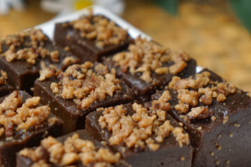 Kuih kole kacang, a steamed Malaysian cake, made with fried green bean flour, coconut milk, and palm sugar.  The decoration of the cake is from coconut oil grease or residue. Selective focus.