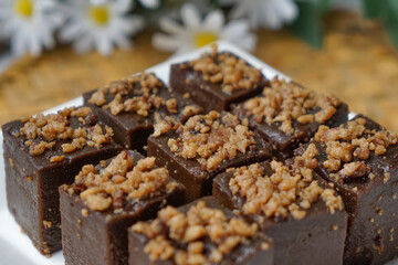 Kuih kole kacang, a steamed Malaysian cake, made with fried green bean flour, coconut milk, and palm sugar.  The decoration of the cake is from coconut oil grease or residue. Selective focus.