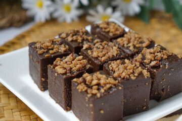 Kuih kole kacang, a steamed Malaysian cake, made with fried green bean flour, coconut milk, and palm sugar.  The decoration of the cake is from coconut oil grease or residue. Selective focus.