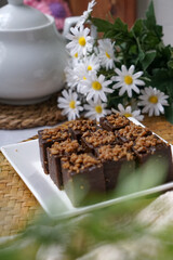 Kuih kole kacang, a steamed Malaysian cake, made with fried green bean flour, coconut milk, and palm sugar.  The decoration of the cake is from coconut oil grease or residue. Selective focus.